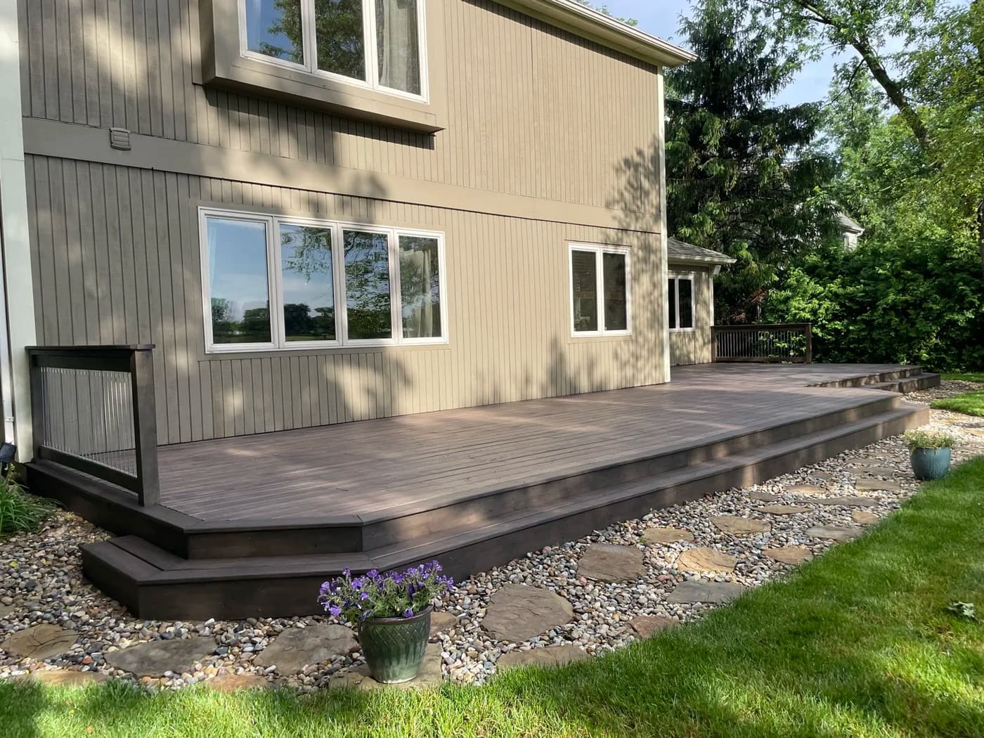 Dark brown composite deck on the back of a modern home