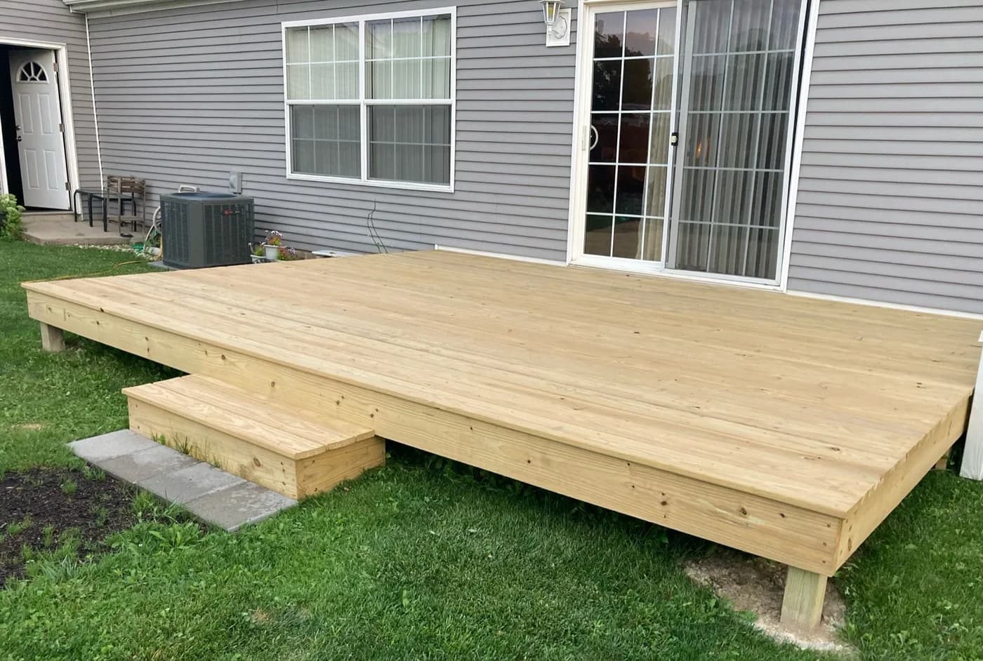 Ground-level pressure-treated wood deck with step entry