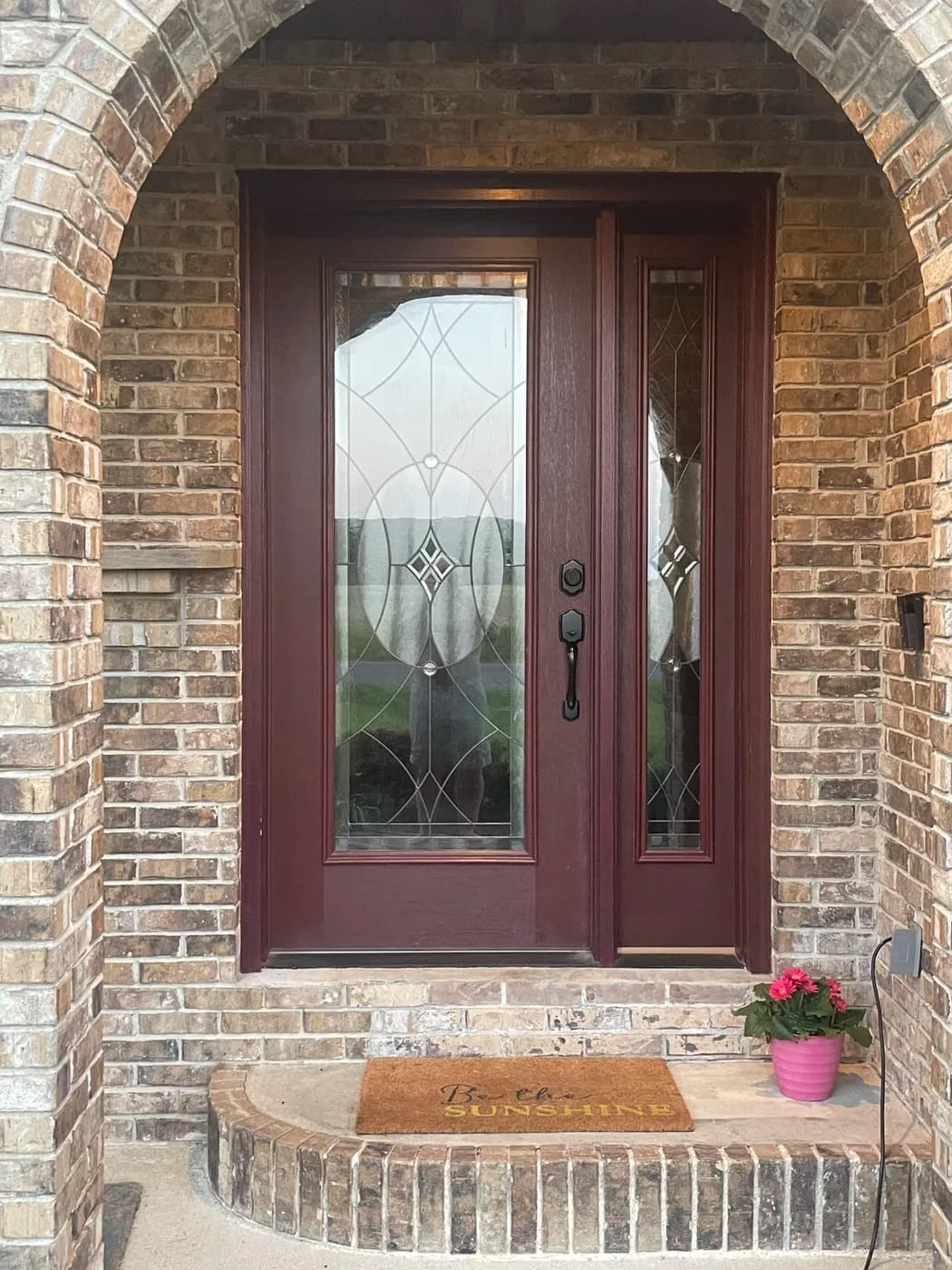 New front entry door with decorative glass on a brick home
