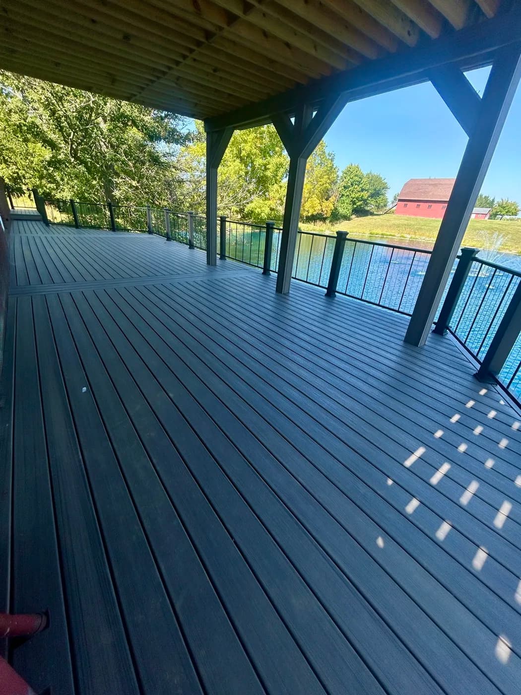 Wide composite deck with cable railings on a lakefront home