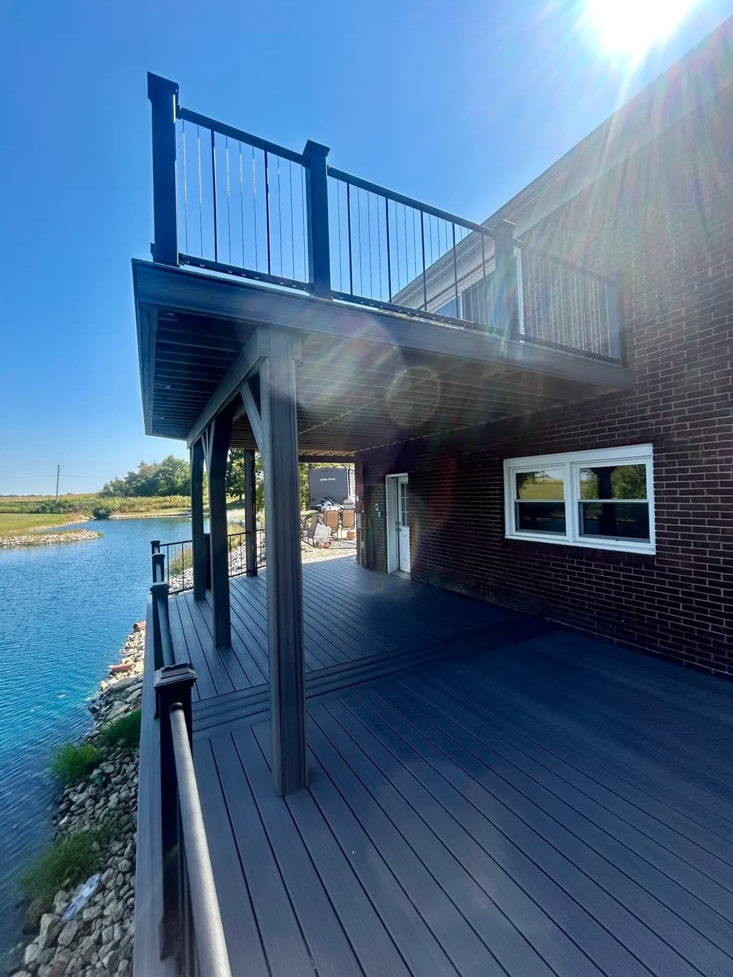 Multi-level composite deck with black aluminum railings on a lakehouse in northeast Indiana